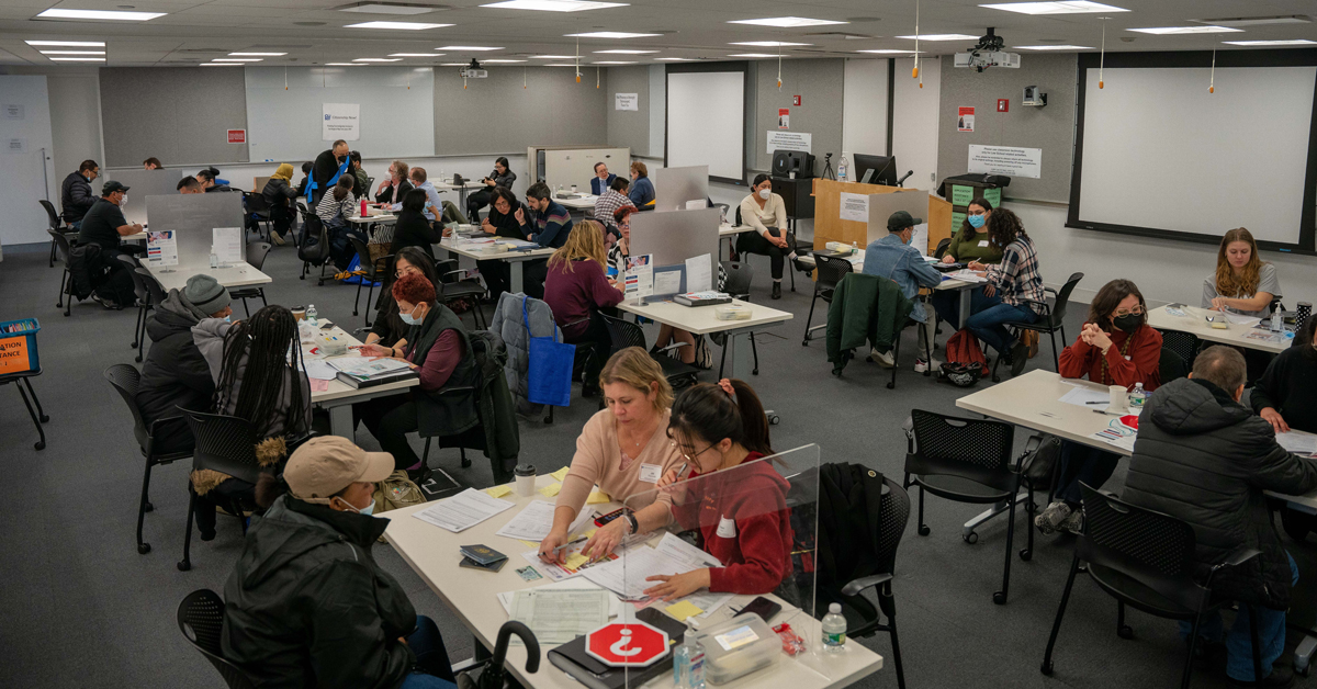 a roomful of people fill out citizenship paperwork