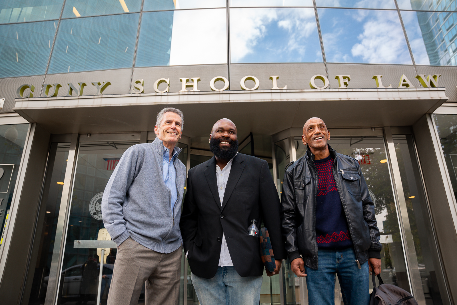 Steven Zeidman, Lorenzo Davidson, and Greg Mingo pose for a photo outside of CUNY Law.