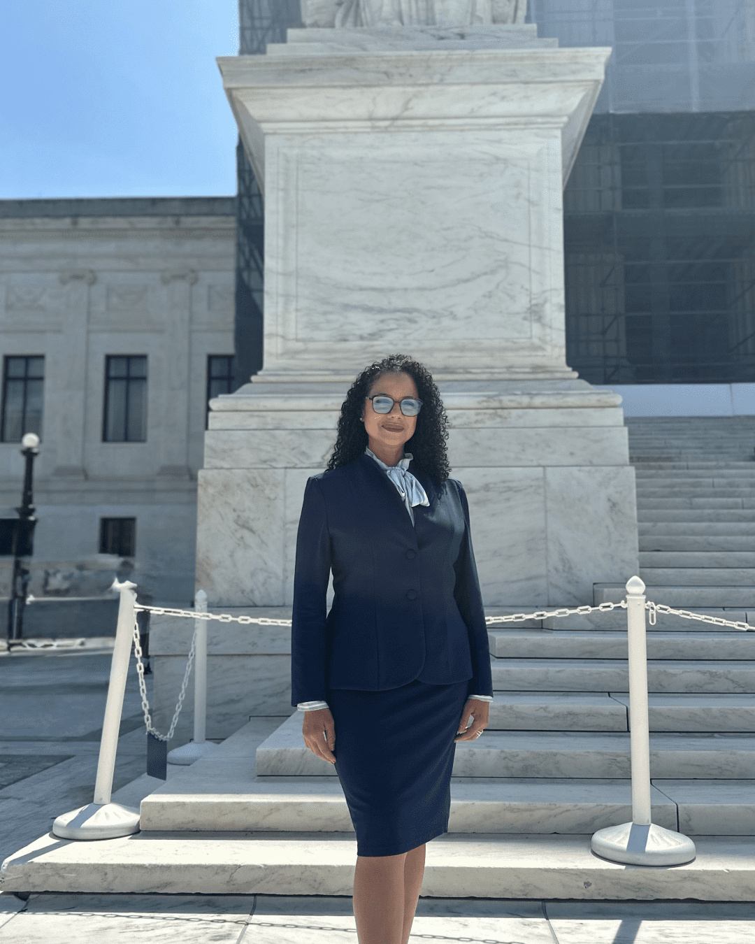A woman in professor attire standing in front of the steps of the U.S. Supreme Court.