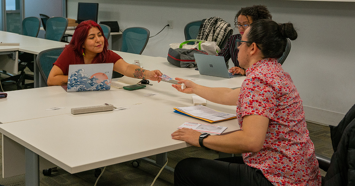 Student Jazmin Ortiz and Raquel Morote counseling Wendell in INRC classroom