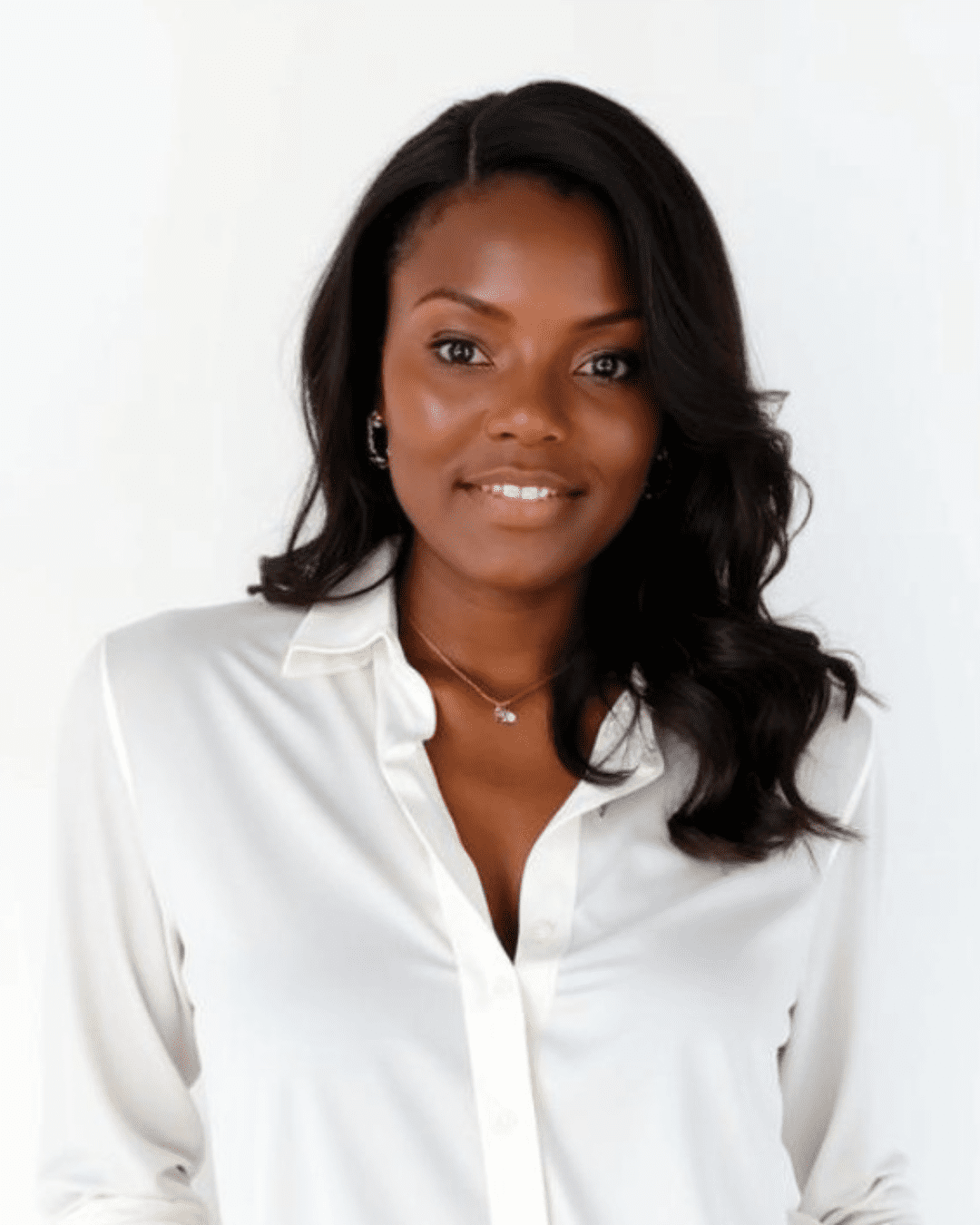A headshot of a woman in a professional white button down blouse.