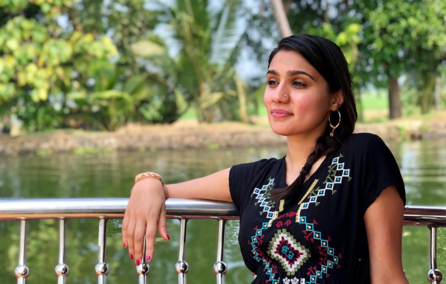 A person leans on a railing before a body of water