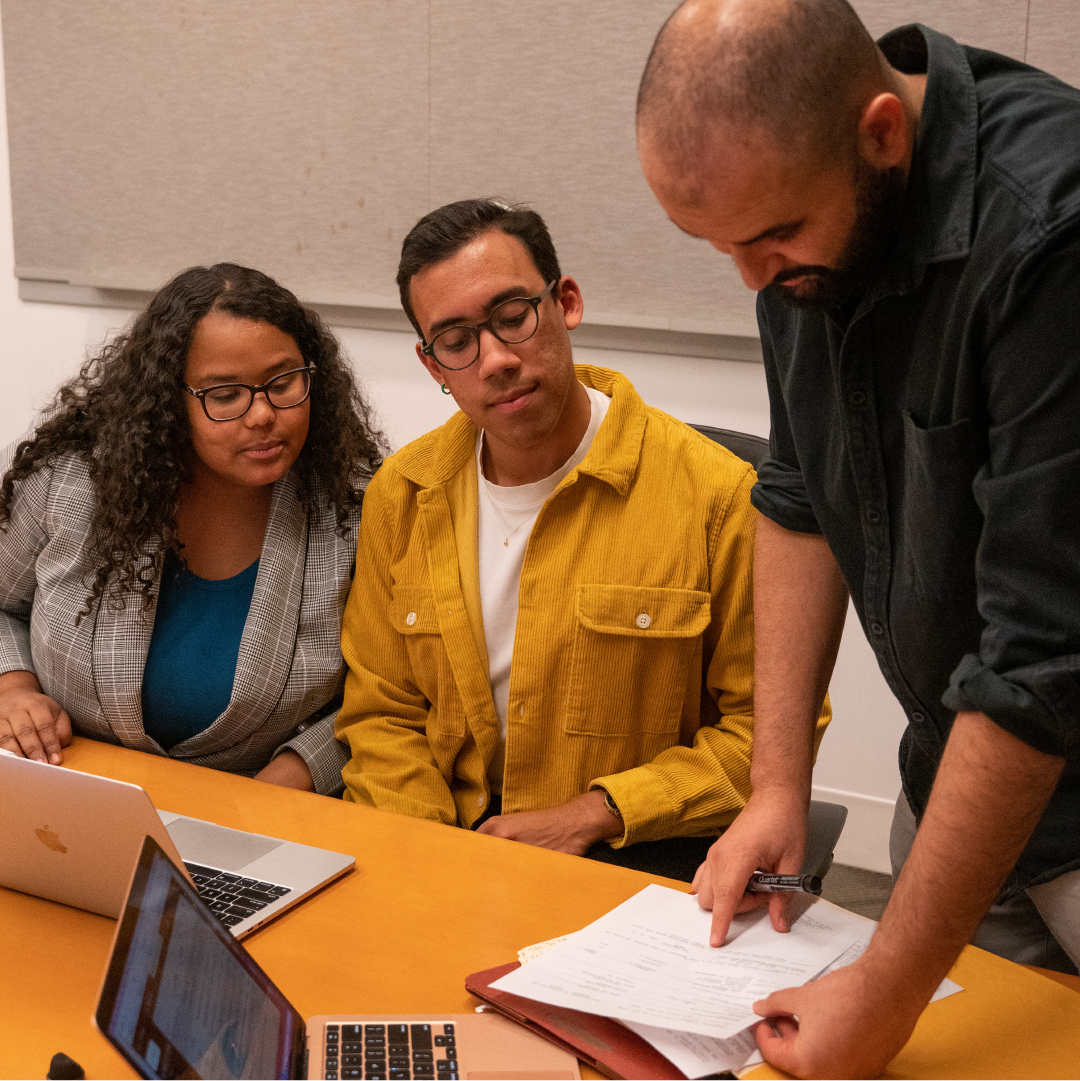 Three people work together at a table