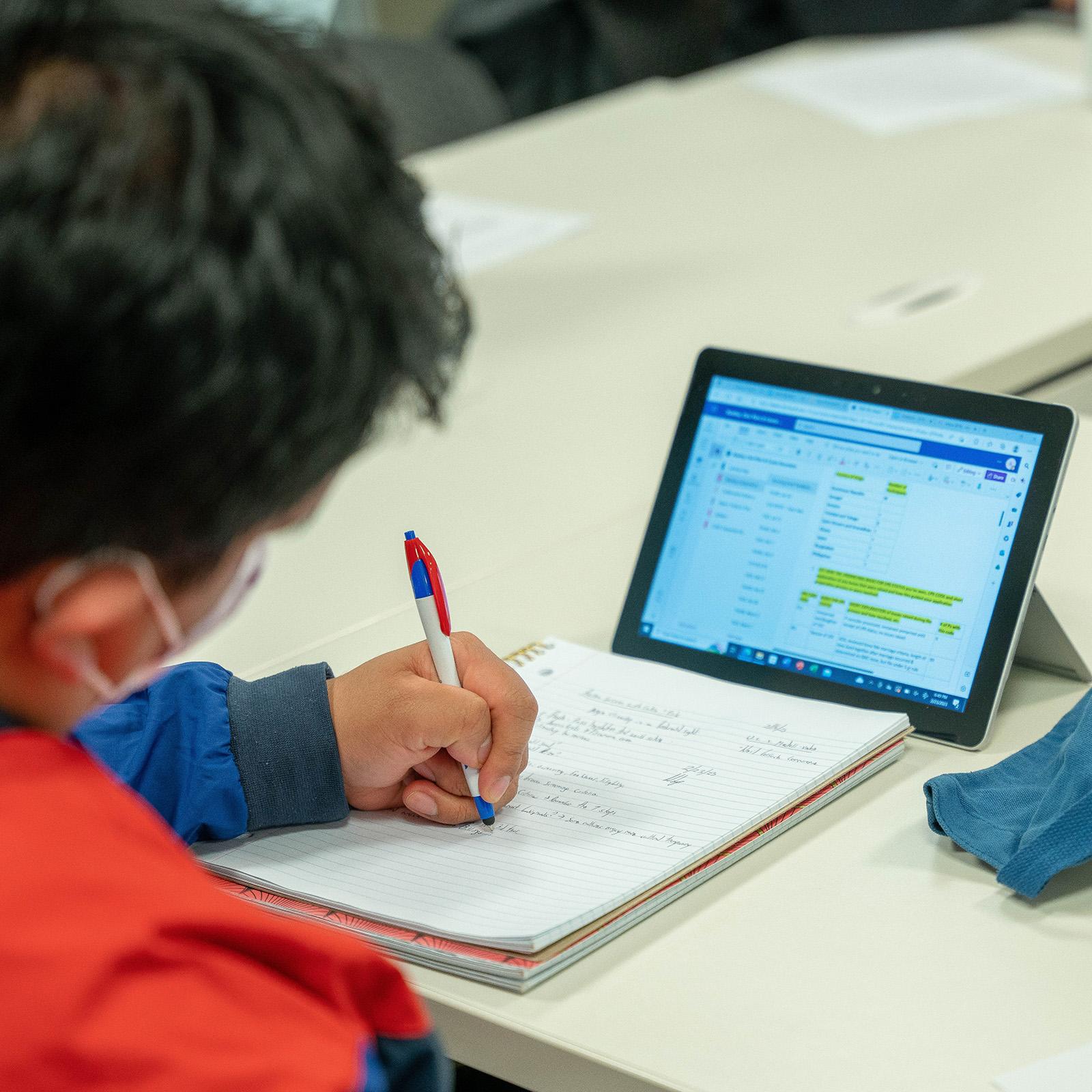 Student taking notes at a table