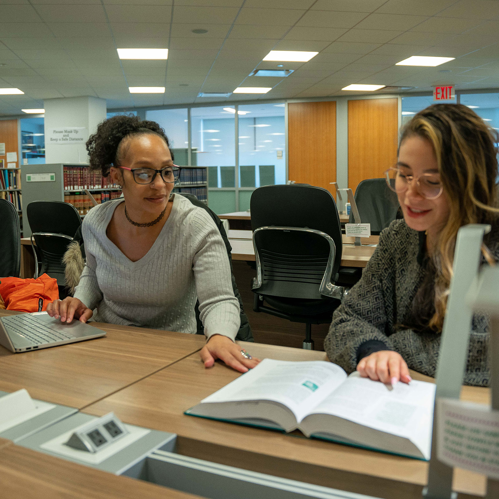 two students studying together in the library