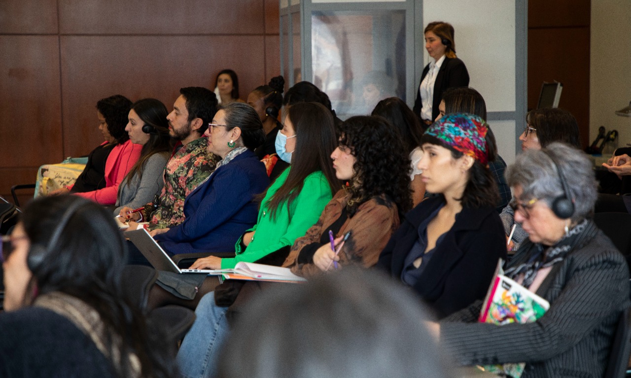 A coalition of men and women listening to Lisa Davis speak on a panel. Lisa Davis is not seen in the photo