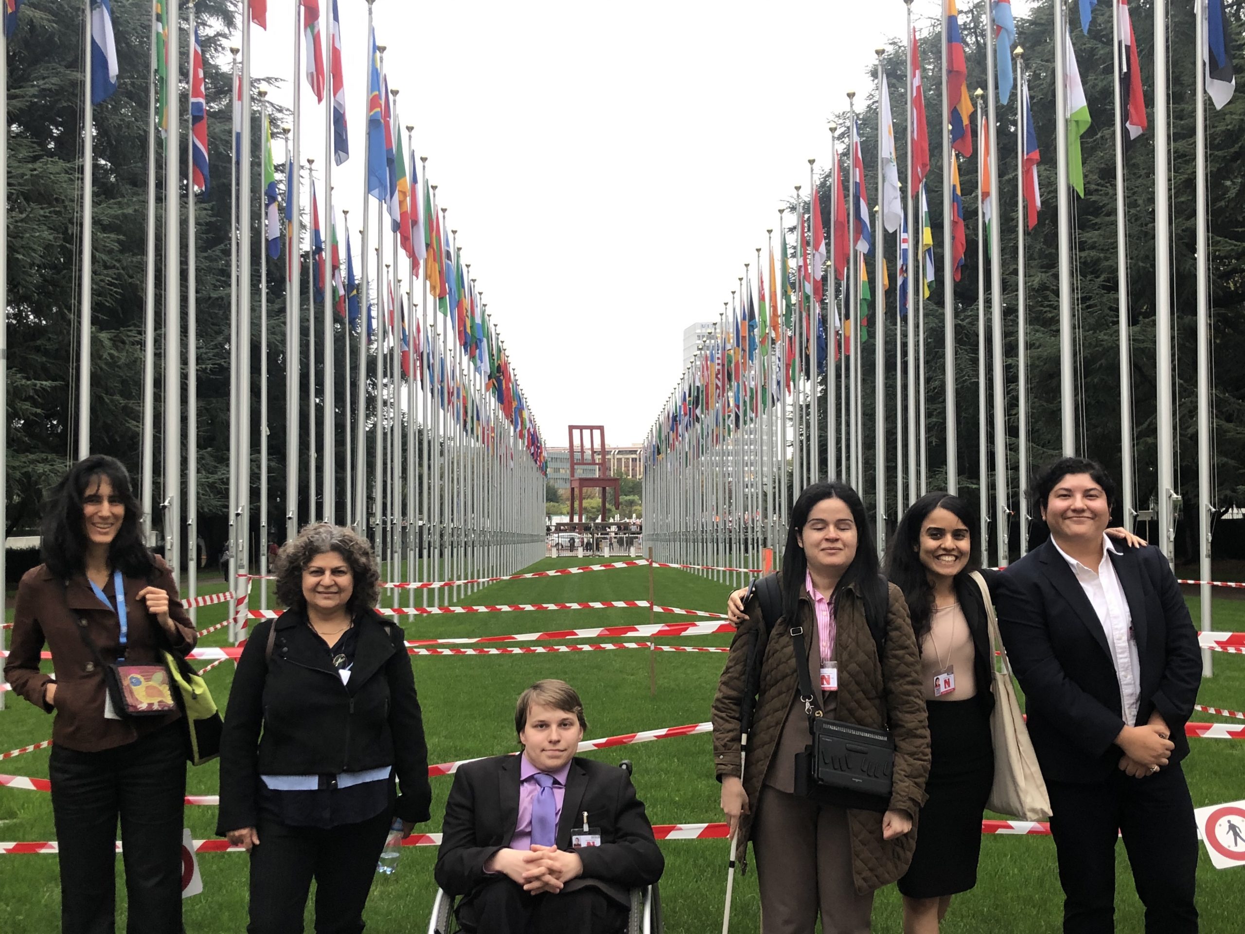 Group of students out between the flags of the countries in front of the UN