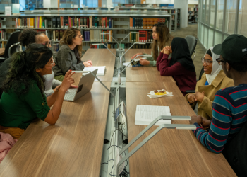 2023-23-02_Students_Collaborating_In_The_Library-25_1080x720- People work and study at a long table in the CUNY Law Library