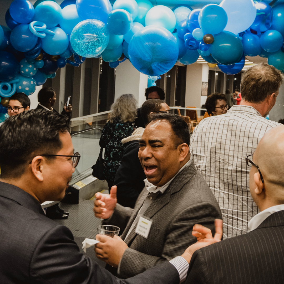 Alumni mingle amidst blue balloon decorations at Reunion