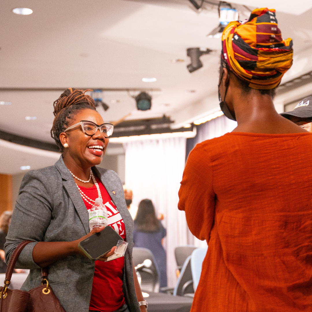 An alumna smiling and talking with CUNY Law students