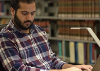 A person works at their laptop in the CUNY Law library