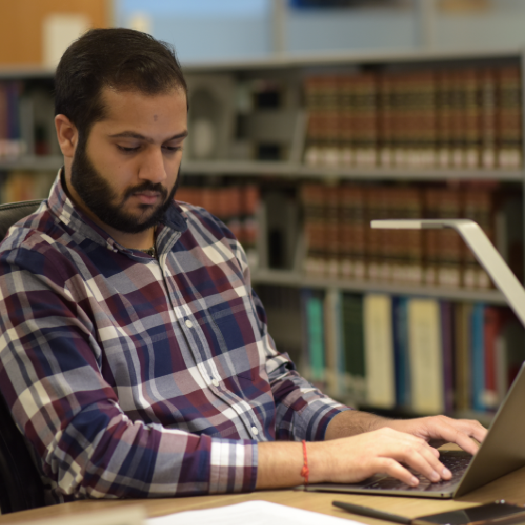 A person works at their laptop in the CUNY Law library