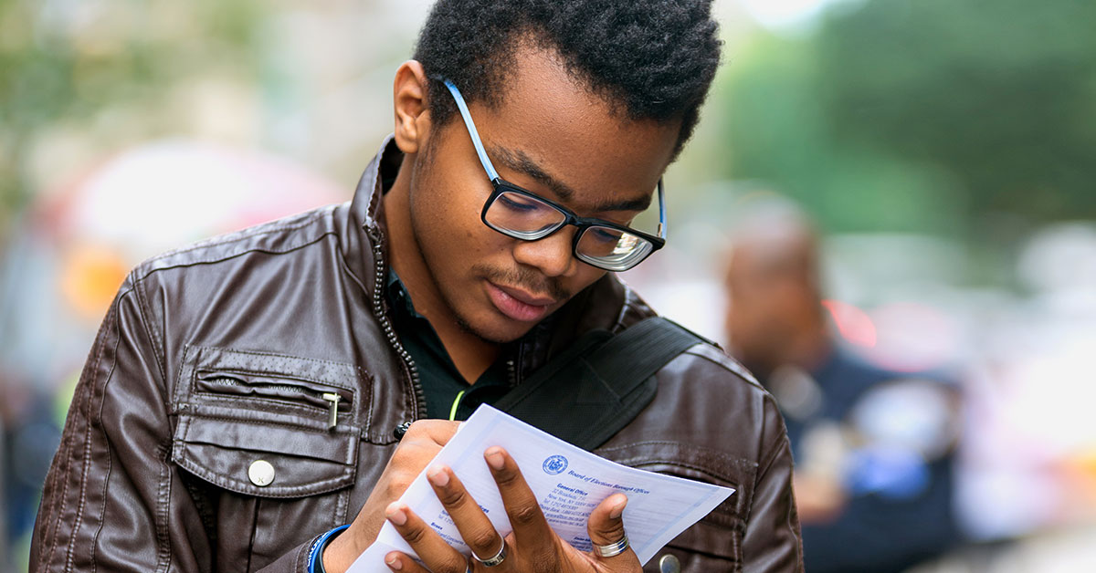 A student fills out a paper voter registration form