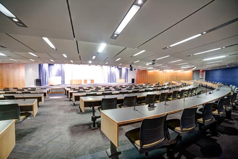 a front view of the stage and the seats in the audience from the back of auditorium.