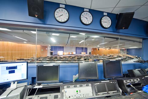 a front view of the stage and the seats in the audience from the back of control room.