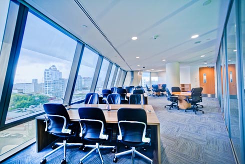 Study tables lining a wall of windows in the library