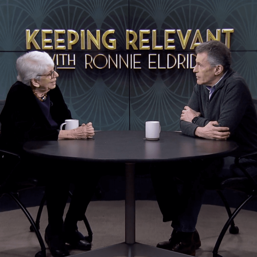 Two people talk in a television studio