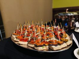 Close up of a plate of bite size bruschetta with toothpicks.