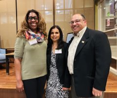 three people posed together facing the camera and smiling Busboys and Poets at the Alumni Happy Hour in DC.