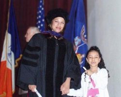 a graduate and her young daughter hold her diploma