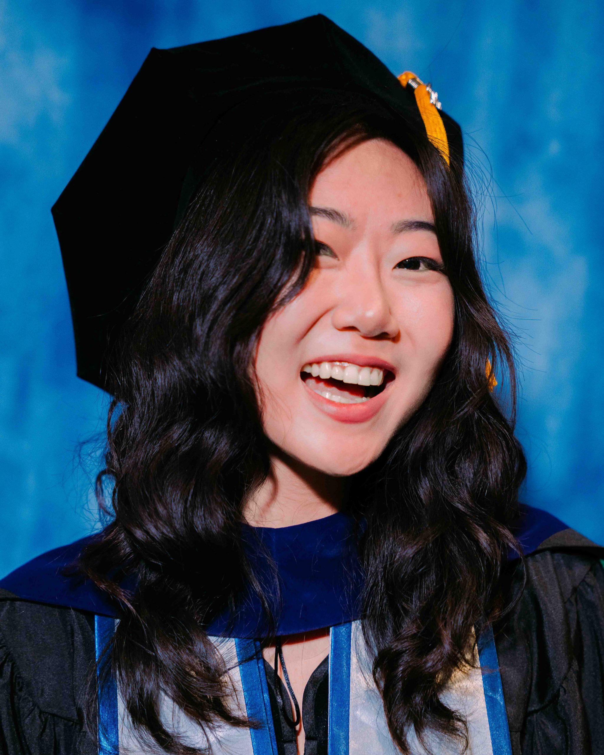 Emily Hong poses for a Graduate portrait in graduation regalia.