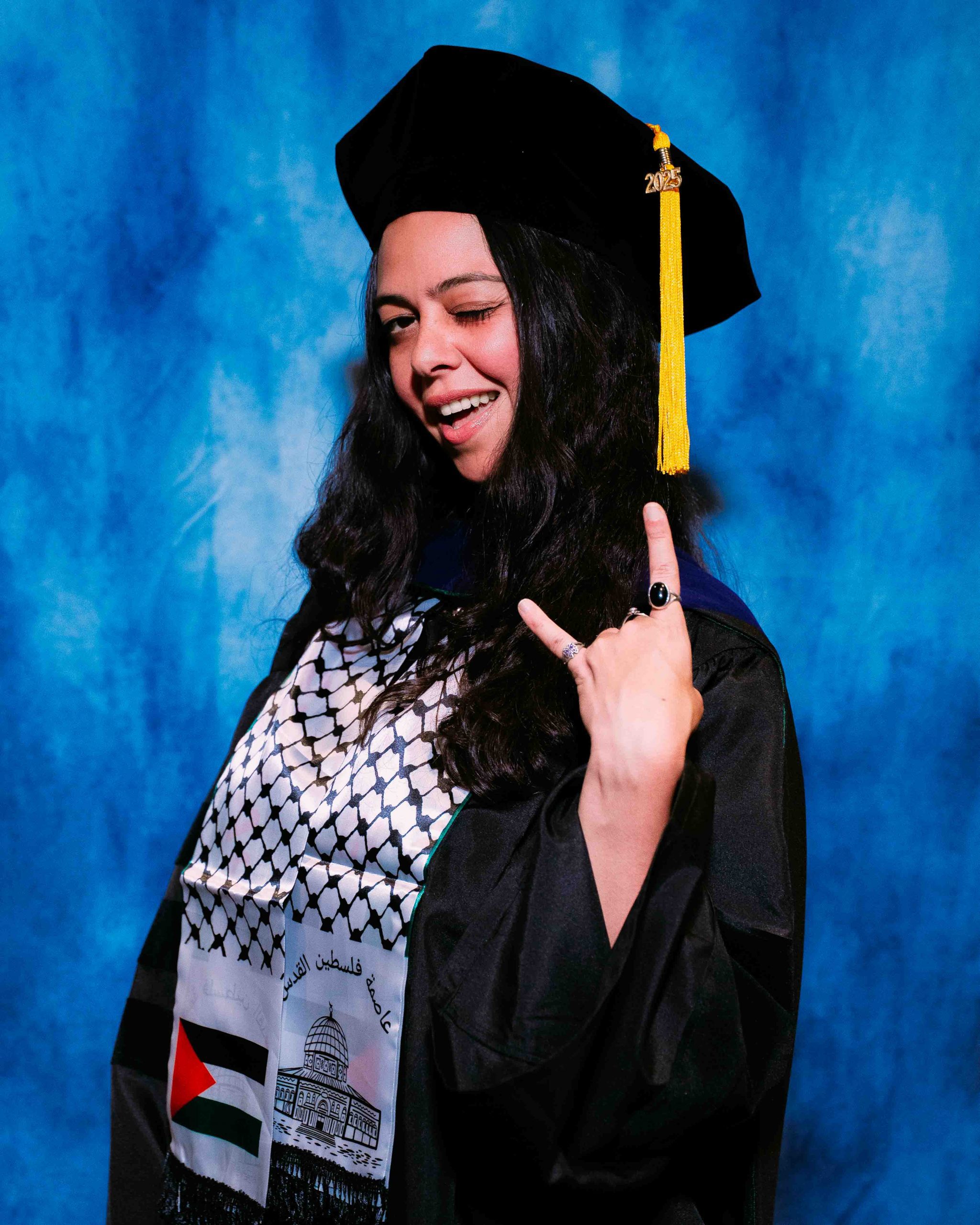 Gabby Aosey poses for a Graduate portrait in graduation regalia.