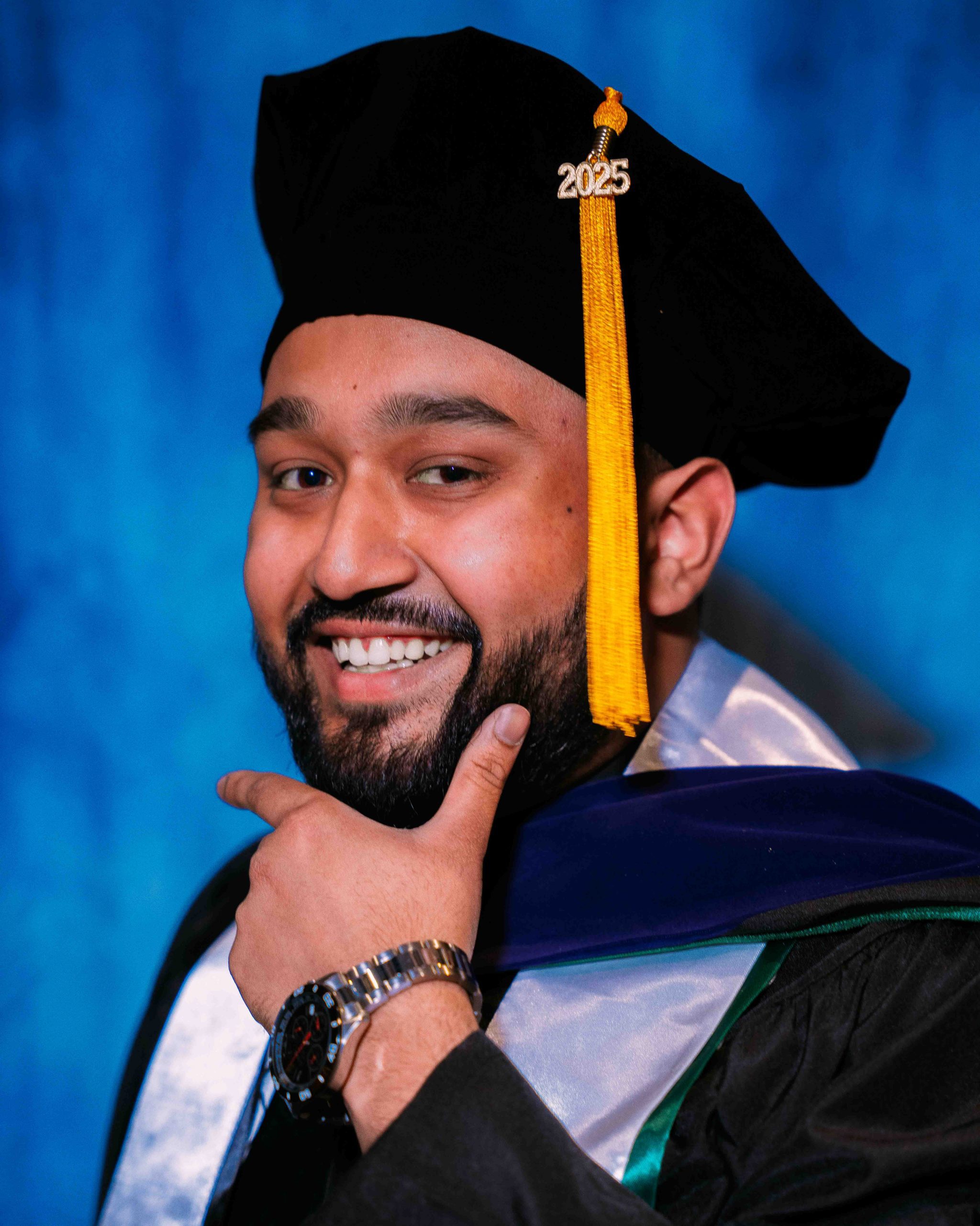 Shahed Chowdhury poses for a Graduate portrait in graduation regalia.